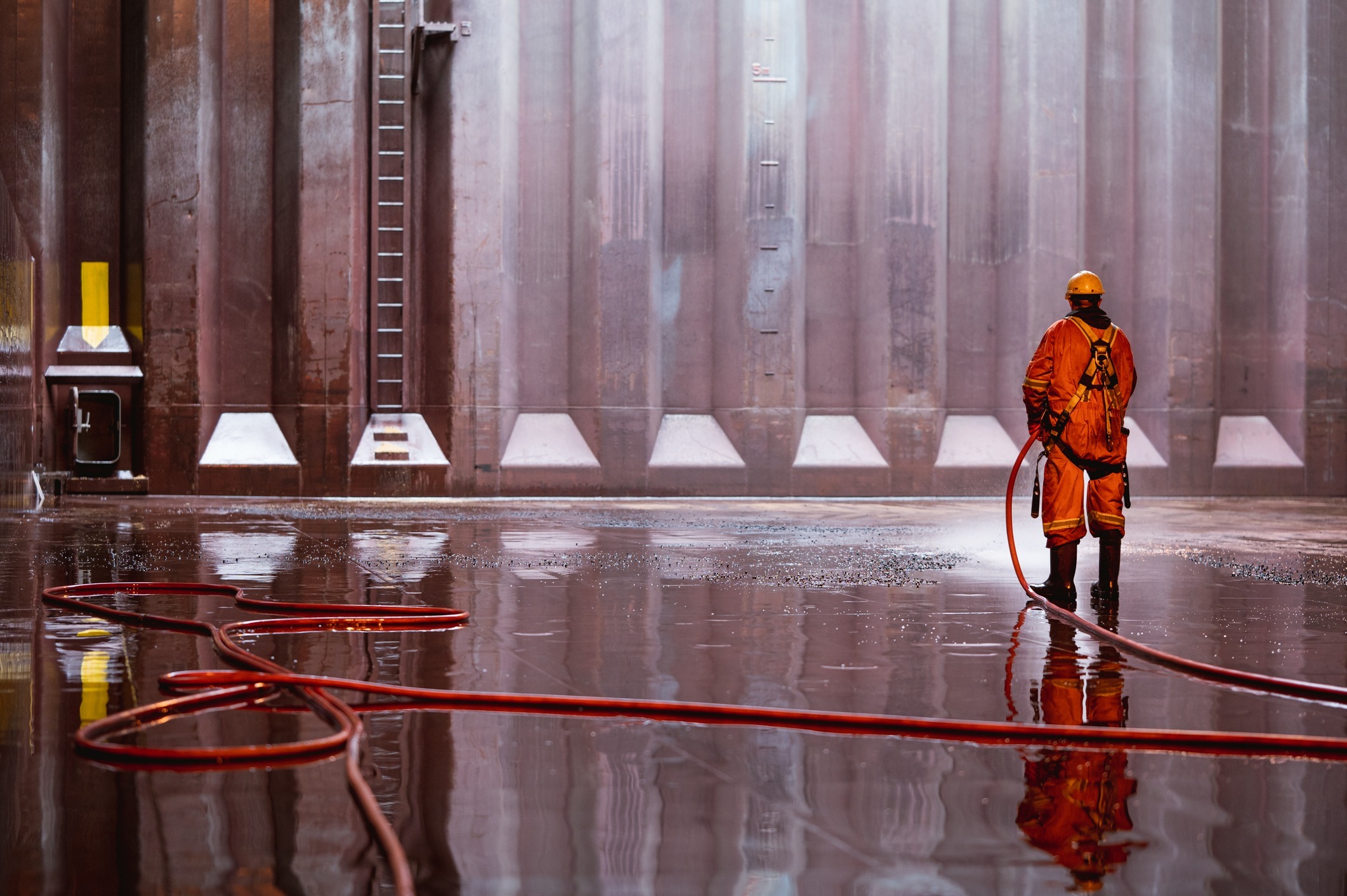 Cargo Maintenance Personnel cleaning cargo hold.
